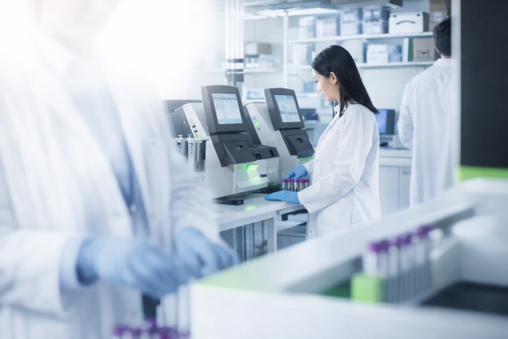 Laboratory technicians using automated analyzers in a modern clinical lab.